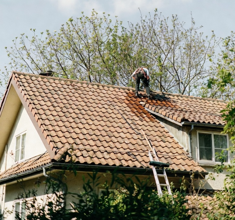 Couvreur professionnel effectuant une inspection et un entretien de toiture au printemps